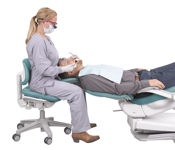 Dentist in ergonomic position with A-dec dental stool and dental chair